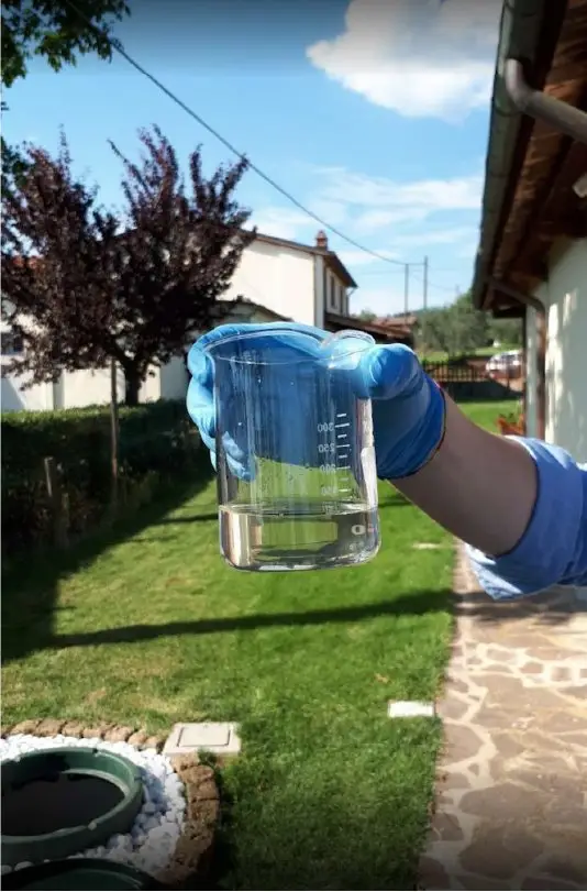 Tecnico che preleva campioni d'acqua per analisi